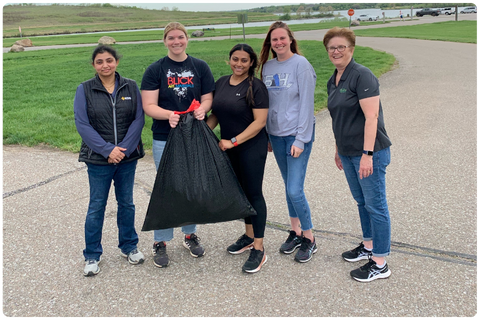 Group pf folks cleaning up litter in a park. 