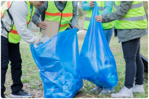 Group of volunteers work together to pick up litter in their community park.